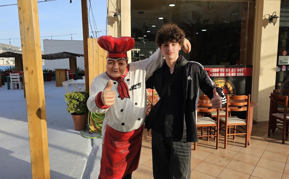 A guest with the pizzeria's chef statue at the entrance