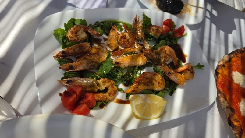 Grilled shrimp on rocket with tomato and lemon